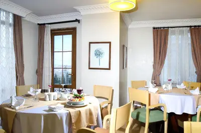 a dining room with two tables and chairs at Grand Gebze Hotel in Gebze