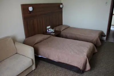 a hotel room with two beds and a couch at Grand Gebze Hotel in Gebze