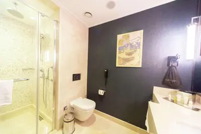 a bathroom with a toilet and a glass shower at Doubletree By Hilton Istanbul Topkapi in Istanbul