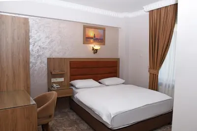 a small bedroom with a bed and a desk at Hotel Grand Umit in Istanbul