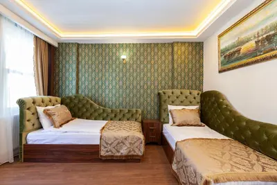 a hotel room with two beds and a couch at Rose Mansion by Otantik Suites in Istanbul