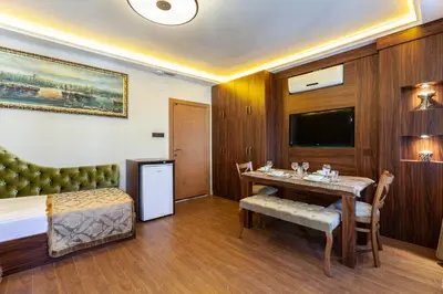 a hotel room with a bed and a table and a television at Rose Mansion by Otantik Suites in Istanbul