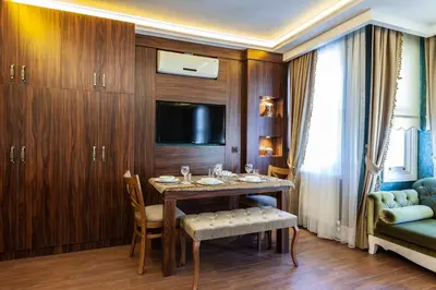 a room with a table and a tv and a couch at Rose Mansion by Otantik Suites in Istanbul
