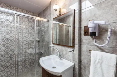 a bathroom with a sink and a shower with a mirror at Rose Mansion by Otantik Suites in Istanbul