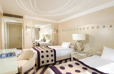 a hotel room with two beds and a chair at Taxim Hill Hotel in Istanbul