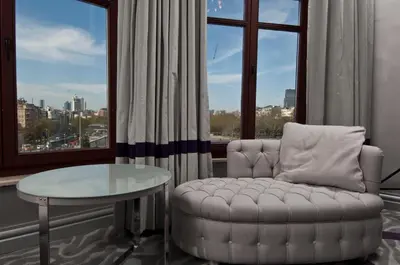 a living room with a chair and a table and a window at Taxim Hill Hotel in Istanbul