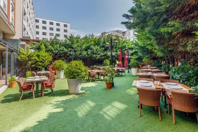 an outdoor patio with tables and chairs and trees at Vicenza Hotel Istanbul Old City in Istanbul