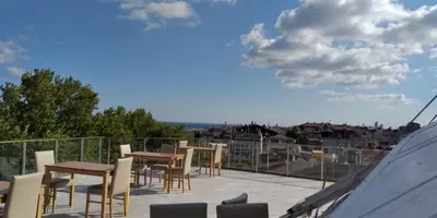 a patio with tables and chairs on a roof at Hotel Yesilpark in Istanbul