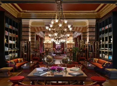 a library with a chandelier and a table and chairs at Pera Palace Hotel in Istanbul