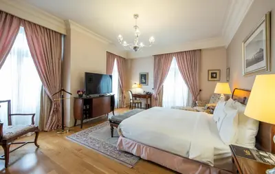 a bedroom with a large bed and a television at Pera Palace Hotel in Istanbul
