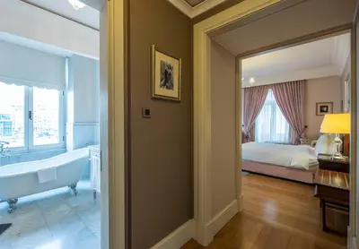 a bathroom with a tub and a bedroom with a bed at Pera Palace Hotel in Istanbul