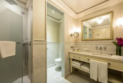 a bathroom with a sink and a toilet and a mirror at Pera Palace Hotel in Istanbul