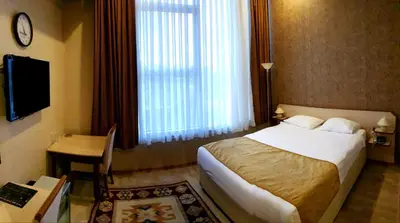 a hotel room with a bed and a desk and a window at EmexOtel Kocaeli in Kocaeli