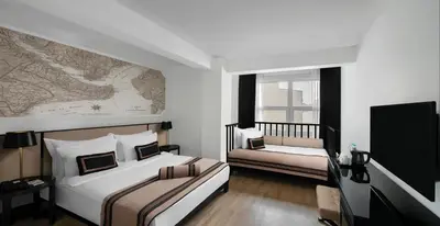 a bedroom with two beds and a map on the wall at AKKA Lush Hotel Taksim in Istanbul