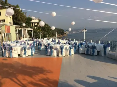 a row of tables and chairs with the ocean in the background at Atamer Doga Resort in Gemlik