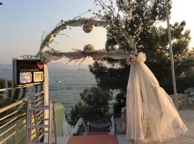 a wedding arch with a white dress and flowers at Atamer Doga Resort in Gemlik