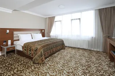 a hotel room with a bed and a large window at Balturk Hotel Sakarya in Sakarya