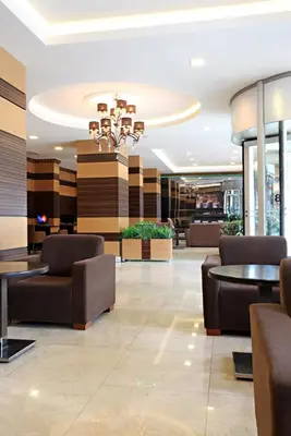 a lobby with chairs and tables and a chandelier at Balturk Hotel Sakarya in Sakarya