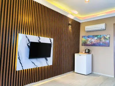 a living room with a television on a wall at Sapanca Aqua Wellness Spa Hotel in Sapanca