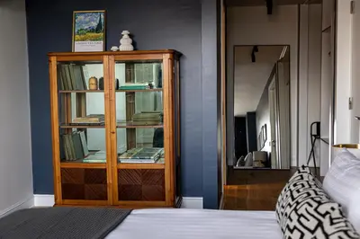 a bedroom with a wooden cabinet with books at GALATA M84 in Istanbul