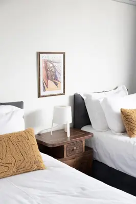 two beds with white sheets and a nightstand between them at GALATA M84 in Istanbul
