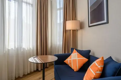 a living room with a blue couch and a table at Four Points Flex by Sheraton Istanbul Taksim Square in Istanbul