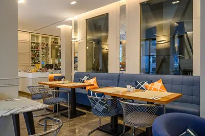 a restaurant with tables and chairs and a blue couch at Four Points Flex by Sheraton Istanbul Taksim Square in Istanbul
