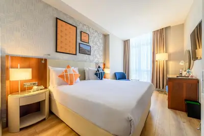 a hotel room with a large bed and a desk at Four Points Flex by Sheraton Istanbul Taksim Square in Istanbul