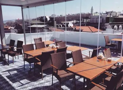 a patio with wooden tables and chairs on a balcony at Flower Palace Hotel in Istanbul