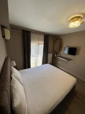 a bedroom with a large white bed and a couch at Flower Palace Hotel in Istanbul