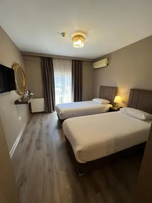 a hotel room with two beds and a window at Flower Palace Hotel in Istanbul