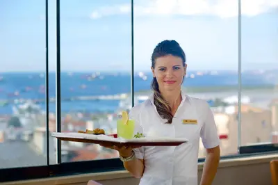 a woman holding a tray of food on a plate at Beethoven Hotel & Suite in Istanbul