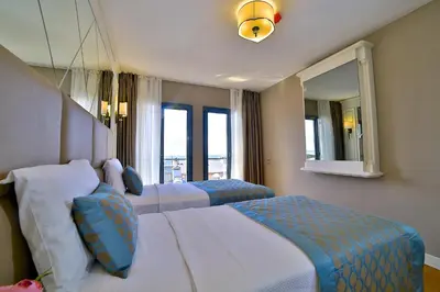 a hotel room with two beds and a mirror at Beethoven Hotel & Suite in Istanbul
