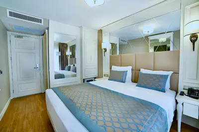 a bedroom with a large bed with blue pillows at Beethoven Hotel & Suite in Istanbul