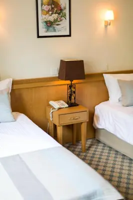 a hotel room with two beds and a table with a lamp at Sidonya Hotel in Istanbul