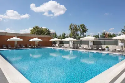 a large swimming pool with chairs and umbrellas at Hilton Istanbul Bakirkoy in Istanbul