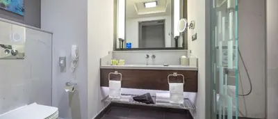 a bathroom with a sink and a toilet and a mirror at Hilton Istanbul Bakirkoy in Istanbul