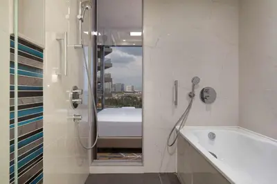 a white bathroom with a shower and a bath tub at Hilton Istanbul Bakirkoy in Istanbul
