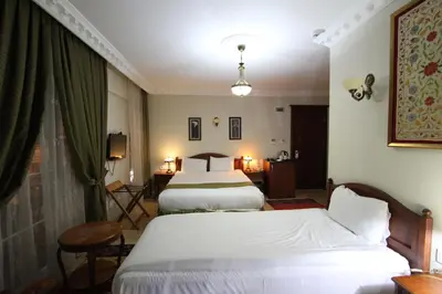 a hotel room with two beds and a window at Basileus Hotel in Istanbul