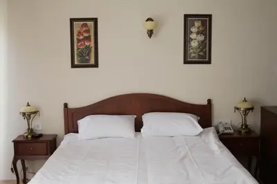 a bedroom with a bed with white sheets and two night stands at Basileus Hotel in Istanbul