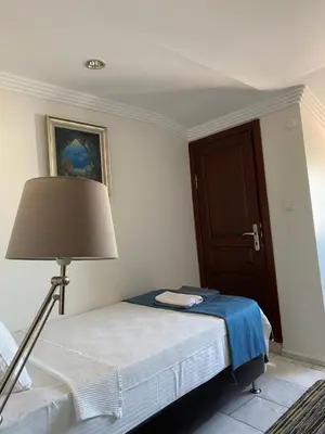 a bedroom with a bed with a lamp and a door at My Kent Hotel in Istanbul