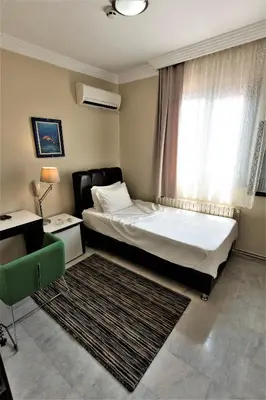 a bedroom with a bed and a window with a rug at My Kent Hotel in Istanbul