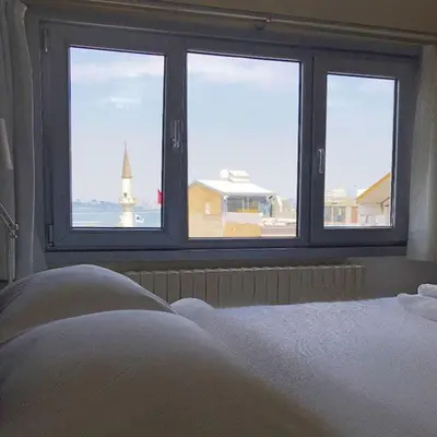 a bedroom with a window with a view of a lighthouse at My Kent Hotel in Istanbul