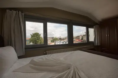 a bedroom with a bed and a large window at My Kent Hotel in Istanbul