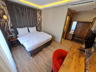 a bedroom with a bed and a chair and a table at Air Boss Istanbul Airport and Fair Hotel in Istanbul