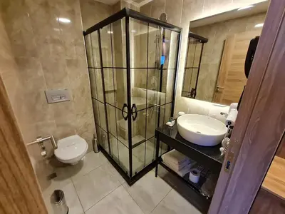a bathroom with a toilet and a sink and a mirror at Air Boss Istanbul Airport and Fair Hotel in Istanbul