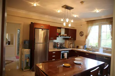 a kitchen with a stainless steel refrigerator and a table at Damla Pansiyon in Sapanca
