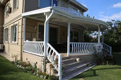 a front porch of a house with a white railing at Damla Pansiyon in Sapanca