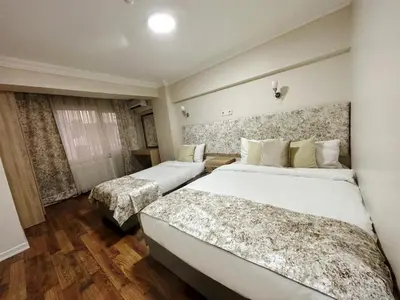 a hotel room with two beds and a window at Antik Ipek Suit in Istanbul