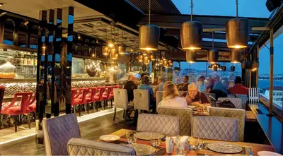 a restaurant with people sitting at tables on the roof at Hotel Momento Golden Horn in Istanbul